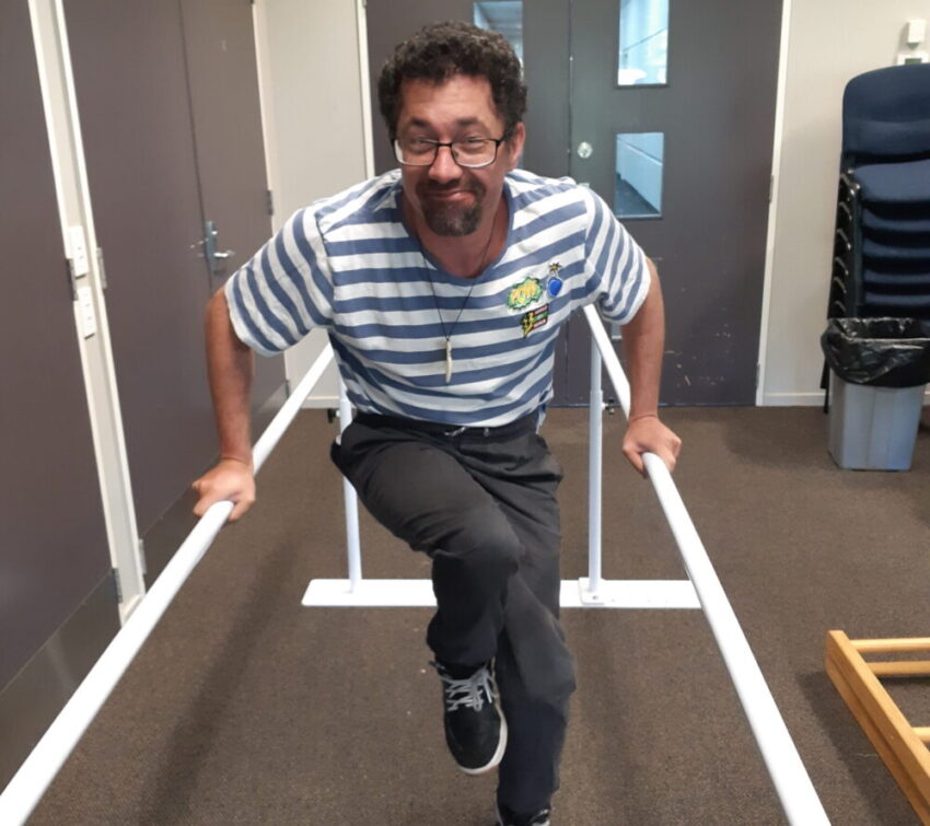 Man walking between two supportive bars