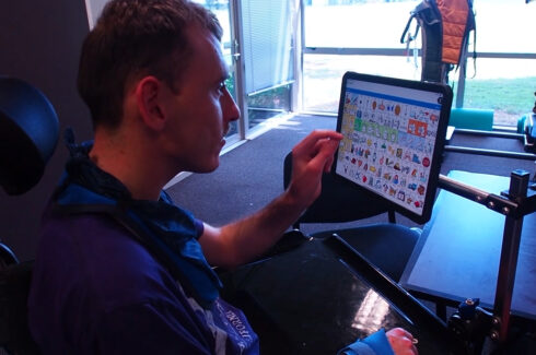 Man in wheelchair using touchscreen tablet