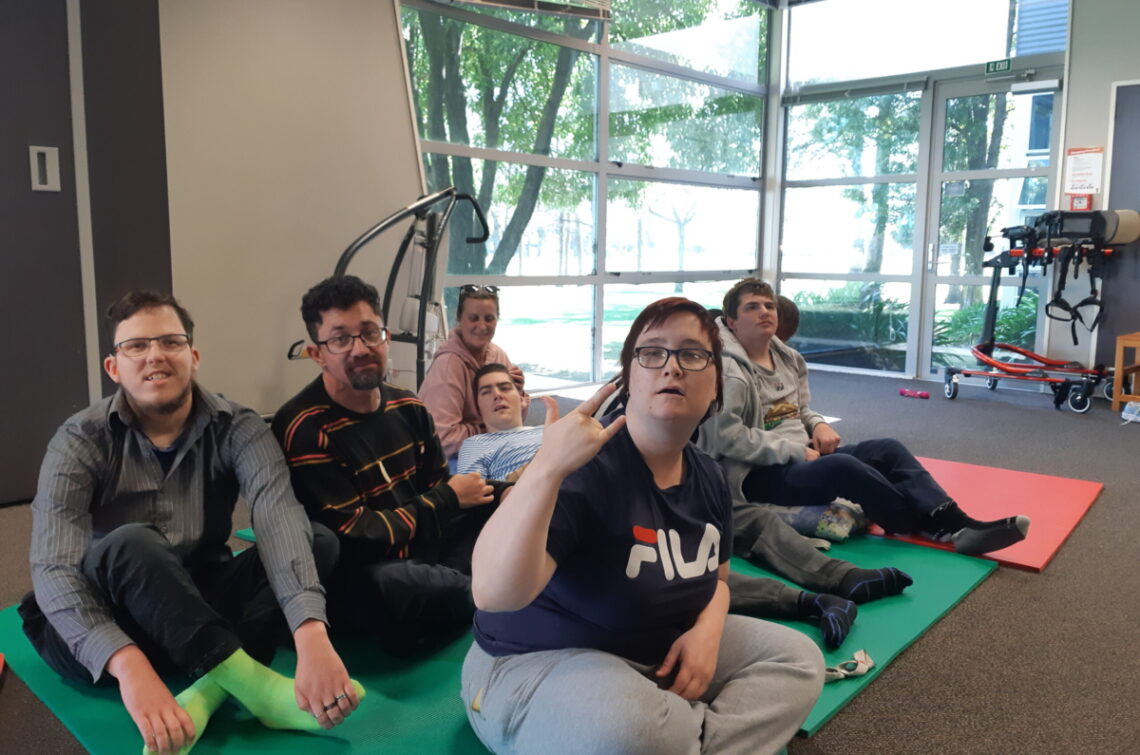 Group of people sitting on a mat on the floor